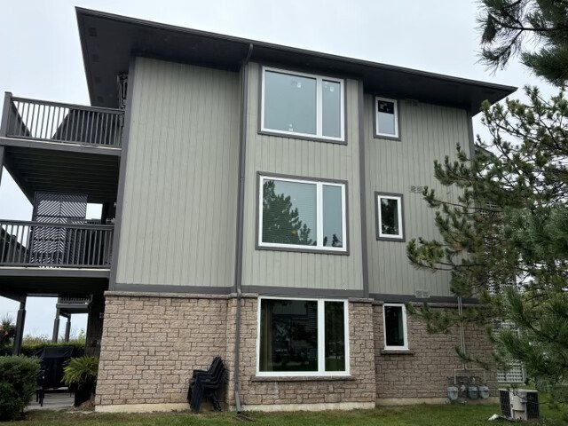 Real WDC project: wide sliding windows across the back wall of a brick and siding home