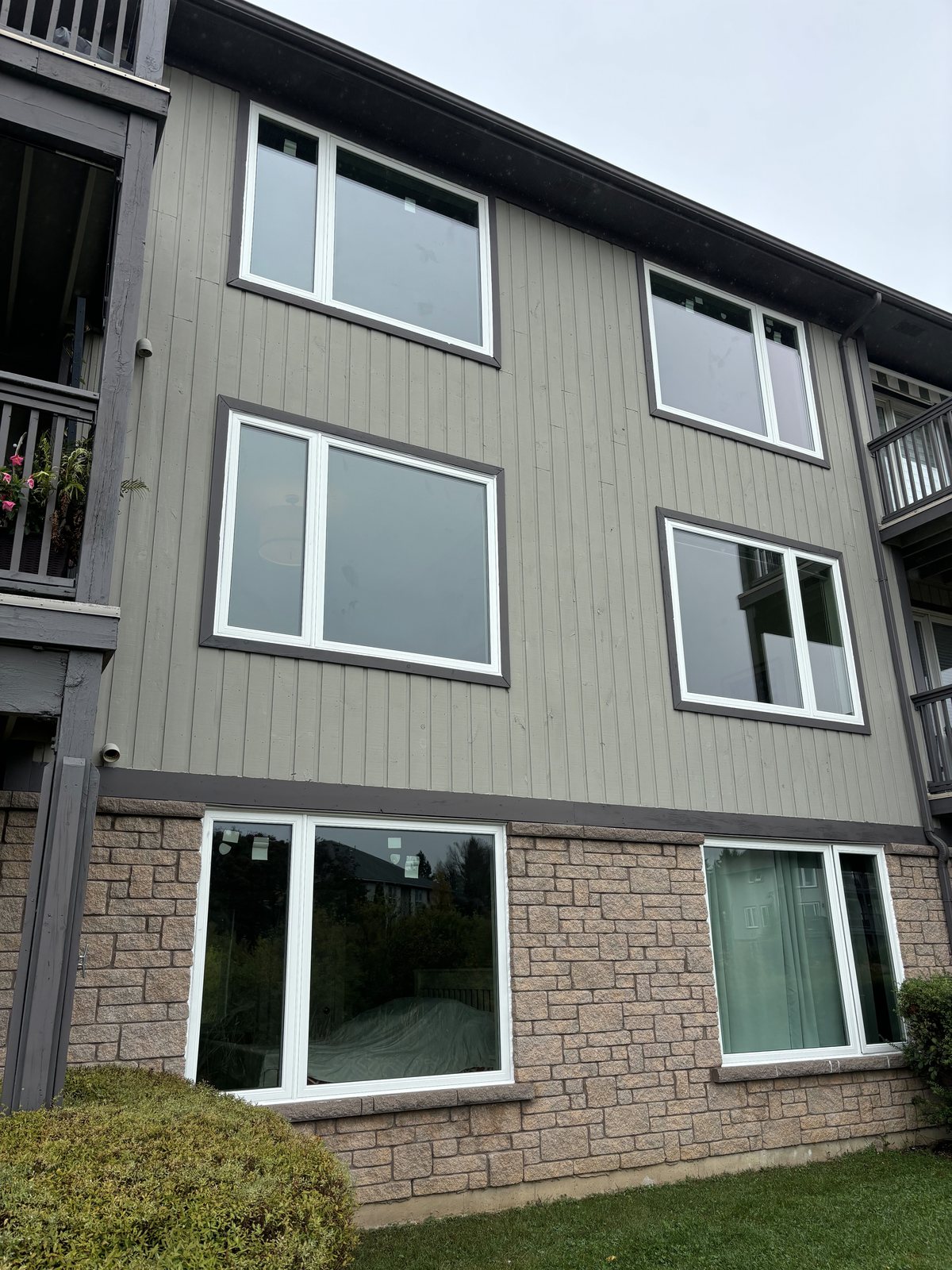 Real WDC project: oversized black-trimmed windows across a brick and siding wall