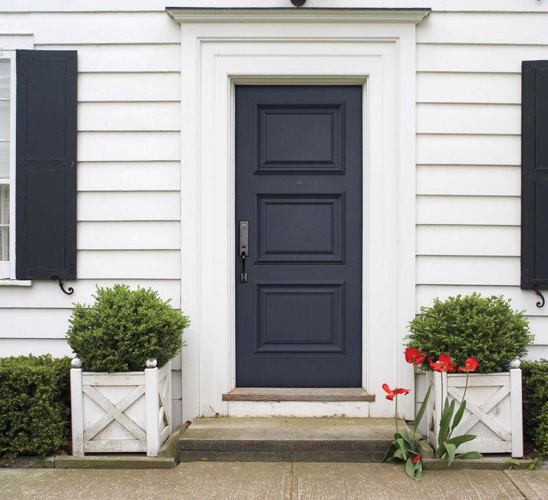 Novatech catalogue photo: classic navy blue entry door on a white siding home